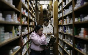 Pharmacy employees check medicine supplies at medicine for sale in a drugstore in Caracas